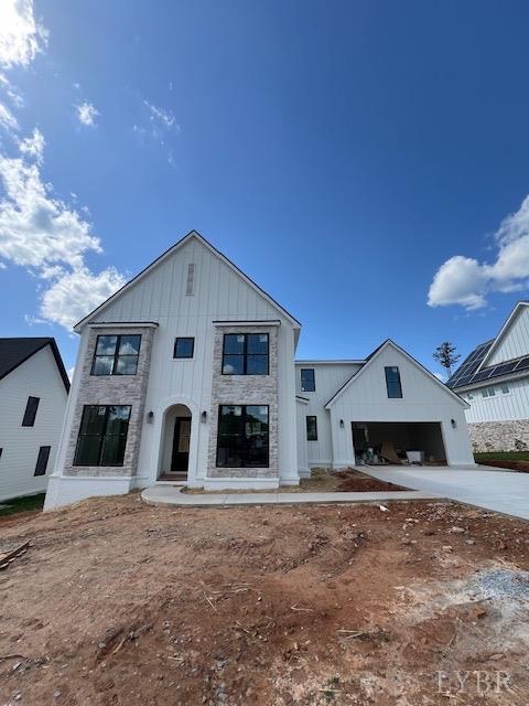 917 Elmwood Ave, Lynchburg, VA 24503 - modern farmhouse featuring concrete driveway, an attached garage, board and batten siding, and stone siding