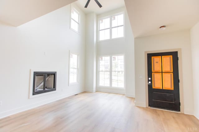 917 Elmwood Ave, Lynchburg, VA 24503 - foyer featuring a glass covered fireplace, light wood finished floors, ceiling fan, a towering ceiling, and baseboards