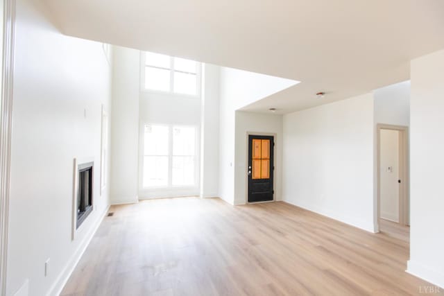 917 Elmwood Ave, Lynchburg, VA 24503 - unfurnished living room featuring light wood-type flooring, a fireplace, and baseboards