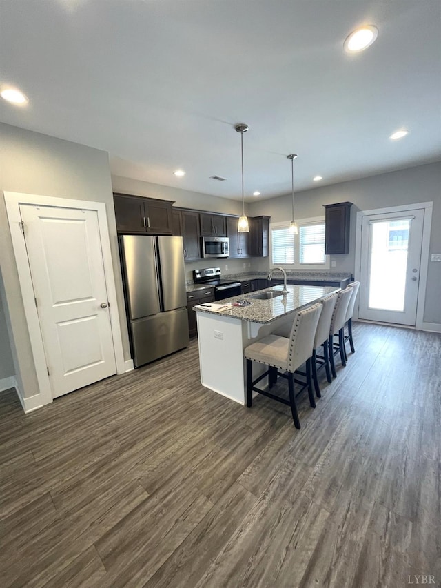 67 Warwick Dr, Lynchburg, VA 24501 - kitchen featuring hanging light fixtures, appliances with stainless steel finishes, an island with sink, sink, and light stone countertops