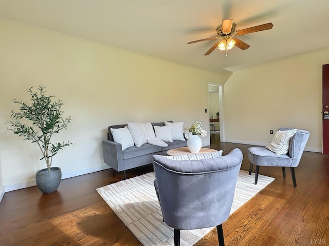 living room featuring baseboards, a ceiling fan, and wood finished floors