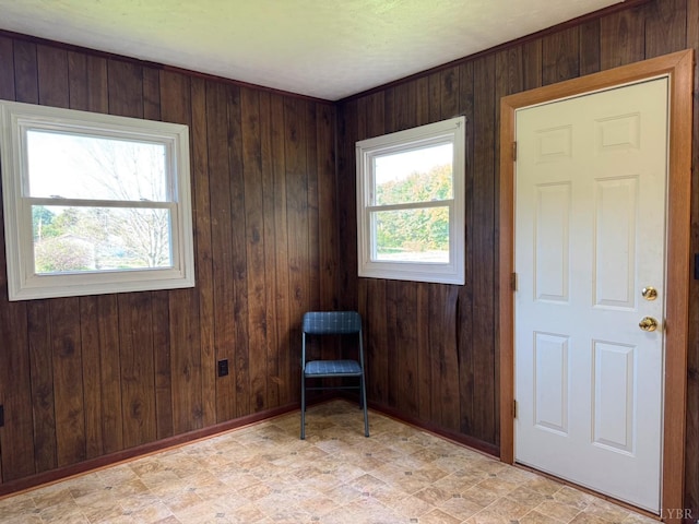 unfurnished room featuring wood walls and baseboards