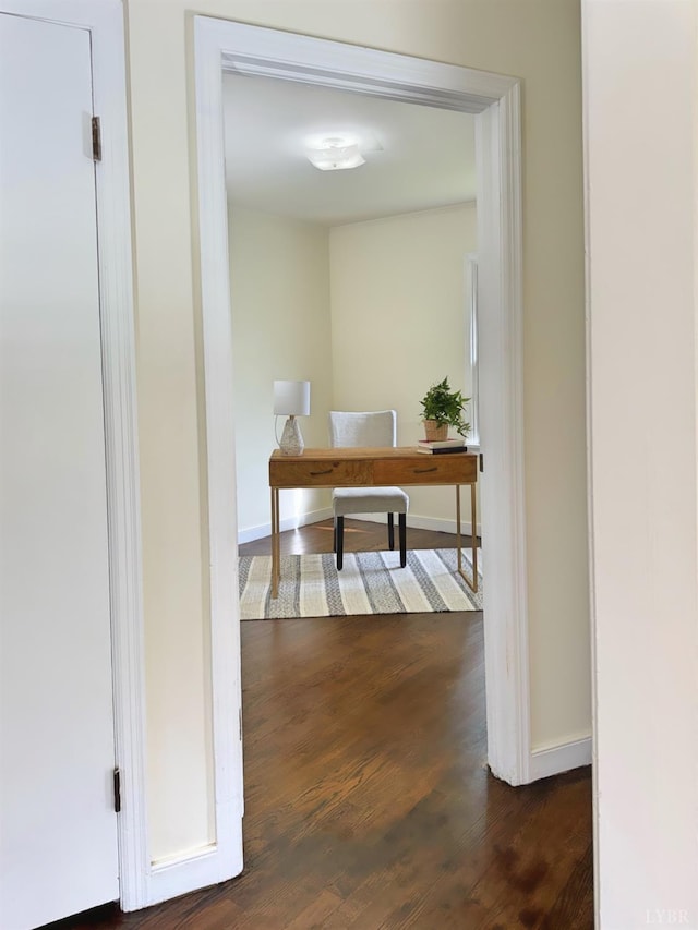 hallway with baseboards and dark wood finished floors