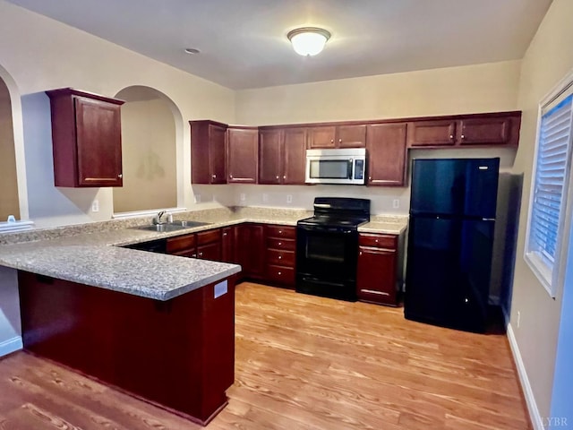 118 Logan Ln, Lynchburg, VA 24502 - kitchen with black appliances, a peninsula, arched walkways, light wood-style floors, and light countertops