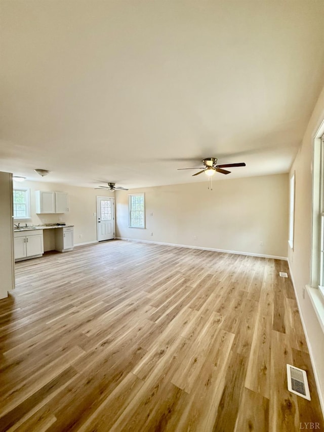 4103 Hogwallow Rd, Nathalie, VA 24577 - unfurnished living room featuring light wood finished floors, ceiling fan, visible vents, and a wealth of natural light