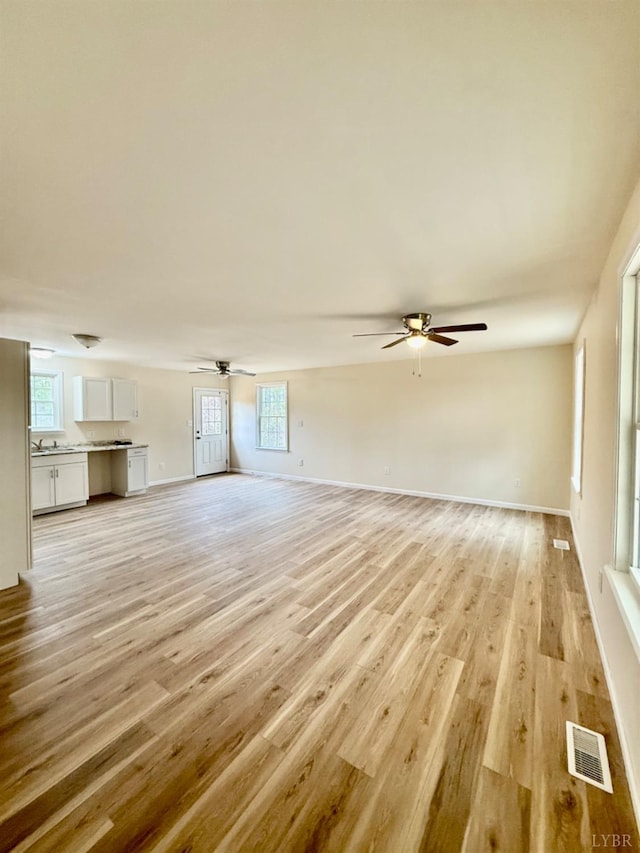 4103 Hogwallow Rd, Nathalie, VA 24577 - unfurnished living room featuring a ceiling fan, plenty of natural light, visible vents, and light wood-style floors