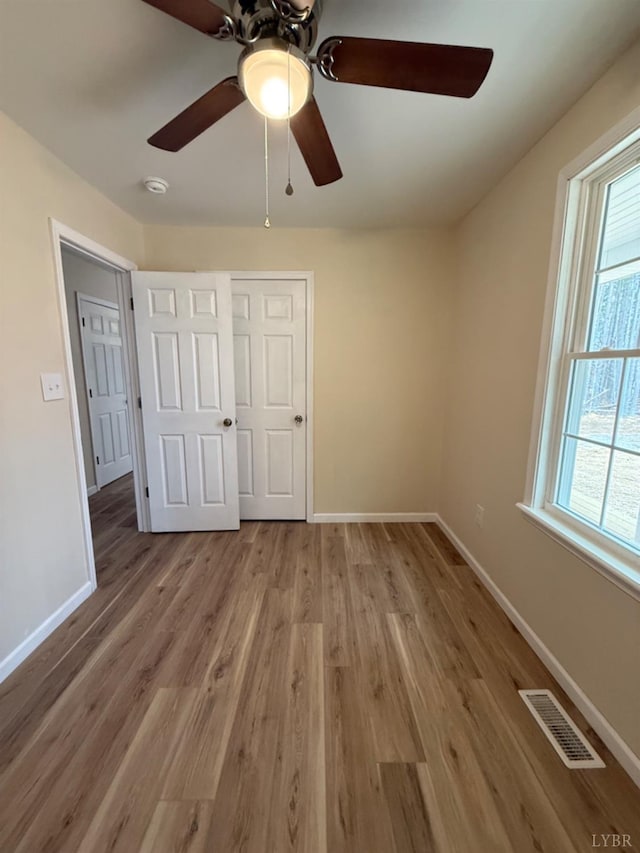 4103 Hogwallow Rd, Nathalie, VA 24577 - unfurnished bedroom featuring light wood-style floors, baseboards, visible vents, and a ceiling fan