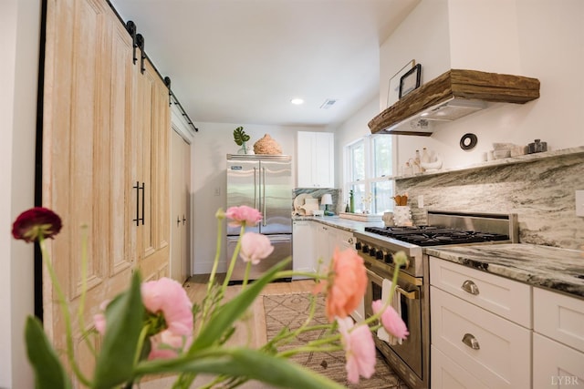1926 Canterbury Ct Unit 301, Lynchburg, VA 24503 - kitchen featuring white cabinets, a barn door, range hood, backsplash, and premium appliances