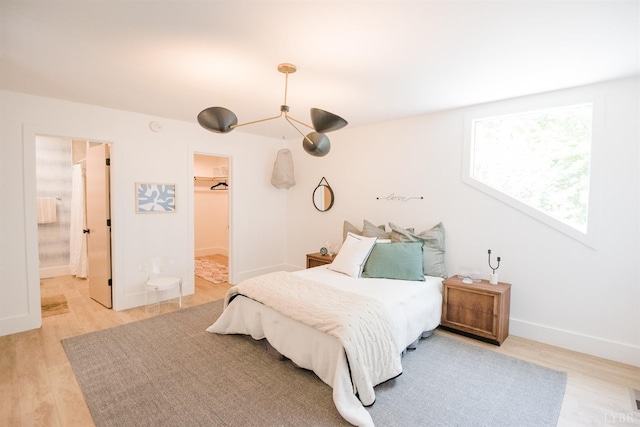 1926 Canterbury Ct Unit 301, Lynchburg, VA 24503 - bedroom featuring connected bathroom, a walk in closet, light wood-style flooring, baseboards, and a closet
