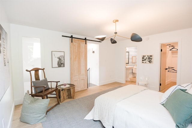 1926 Canterbury Ct Unit 301, Lynchburg, VA 24503 - bedroom with ensuite bathroom, a barn door, baseboards, and light wood-style flooring