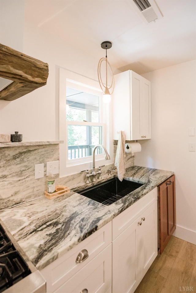 1926 Canterbury Ct Unit 301, Lynchburg, VA 24503 - kitchen featuring a sink, white cabinets, light stone countertops, and light wood-style flooring