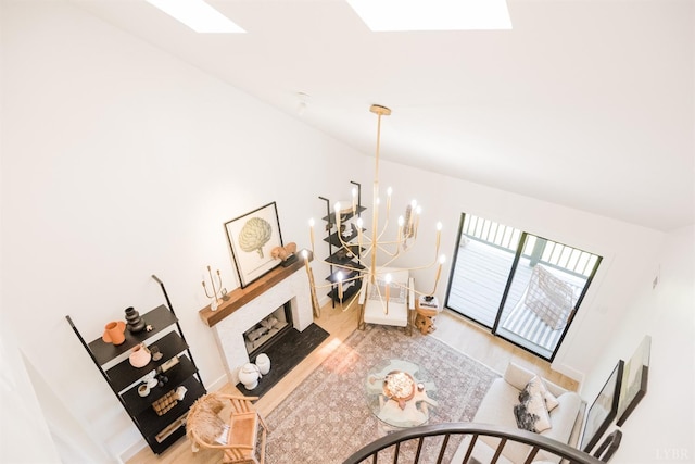 1926 Canterbury Ct Unit 301, Lynchburg, VA 24503 - living area featuring a brick fireplace, wood finished floors, baseboards, a notable chandelier, and a skylight