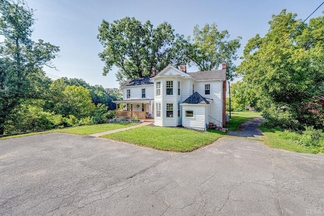 1038 Valencia Dr, Huddleston, VA 24101 - view of front facade with a chimney, a front lawn, driveway, and a porch