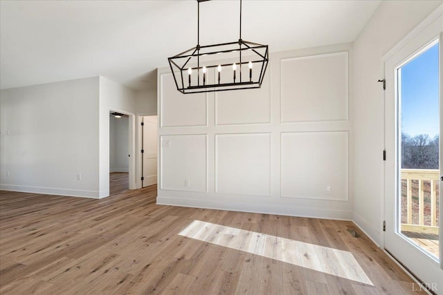 2802 Liberty Chapel Rd, Appomattox, VA 24522 - unfurnished dining area with a chandelier, light wood-style flooring, and baseboards