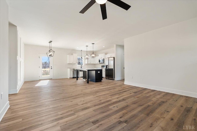 2802 Liberty Chapel Rd, Appomattox, VA 24522 - unfurnished living room featuring ceiling fan, baseboards, light wood-type flooring, and a sink