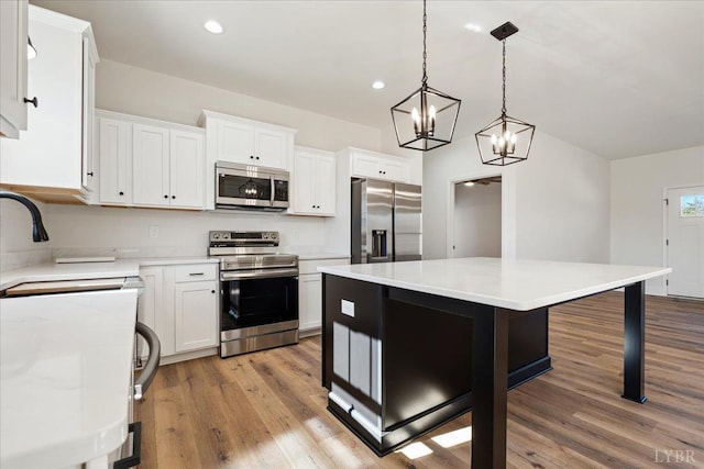 2802 Liberty Chapel Rd, Appomattox, VA 24522 - kitchen with stainless steel appliances, light wood finished floors, white cabinets, a chandelier, and recessed lighting