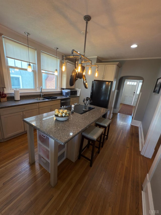 318 Westover Blvd, Lynchburg, VA 24501 - kitchen featuring arched walkways, black appliances, a kitchen bar, a sink, and a center island