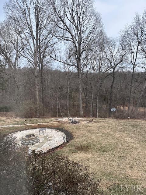 3567 Gregory Ln, Lynchburg, VA 24503 - view of grassy yard featuring an outdoor fire pit and a forest view