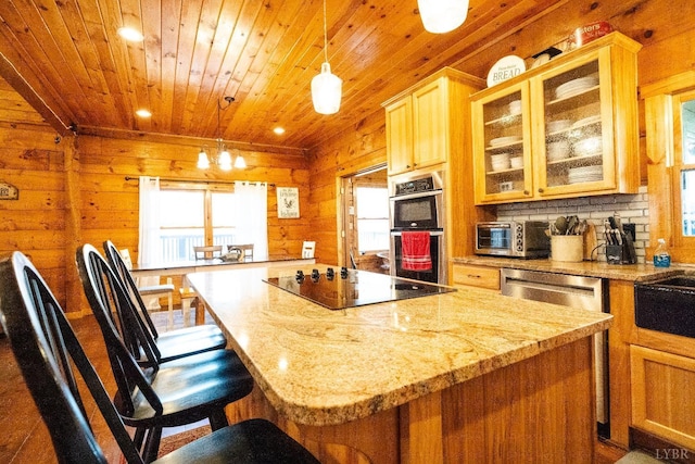 1582 Venturous Trl, Goode, VA 24556 - kitchen featuring wood walls, a kitchen island, wood ceiling, light stone countertops, and appliances with stainless steel finishes