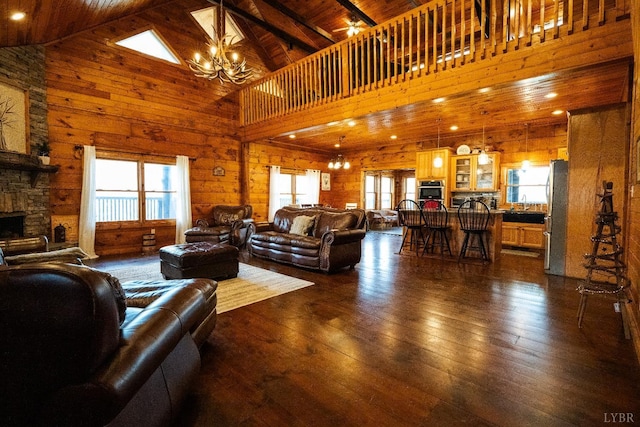 1582 Venturous Trl, Goode, VA 24556 - living room with a wealth of natural light, wood walls, a notable chandelier, and dark wood finished floors