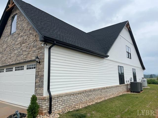 43 Grandset Dr, Forest, VA 24551 - view of side of home featuring a shingled roof, stone siding, cooling unit, and an attached garage