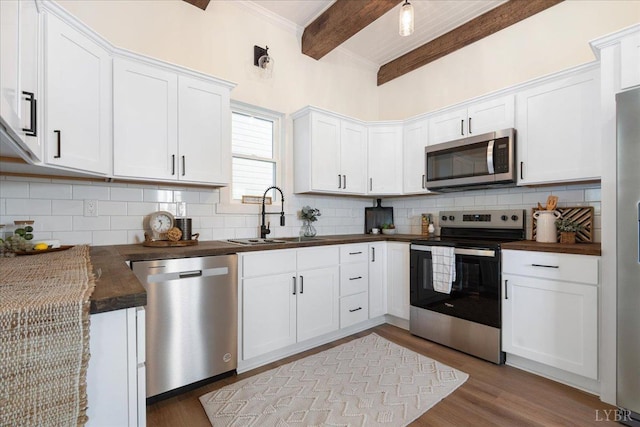 119 Ves Rd, Lynchburg, VA 24503 - kitchen featuring appliances with stainless steel finishes, beamed ceiling, tasteful backsplash, dark countertops, and white cabinetry