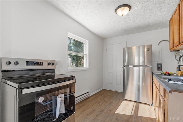 1209 15th St, Lynchburg, VA 24504 - kitchen with baseboard heating, a textured ceiling, light wood finished floors, dark countertops, and appliances with stainless steel finishes