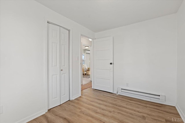 1209 15th St, Lynchburg, VA 24504 - unfurnished bedroom with a baseboard radiator, a closet, light wood-type flooring, and baseboards