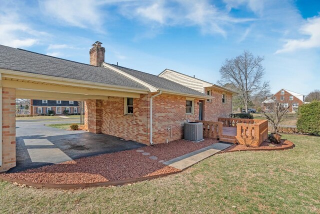 337 Virginia Ave, Appomattox, VA 24522 - rear view of property with central AC, a yard, brick siding, a chimney, and a carport