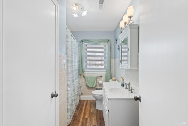 337 Virginia Ave, Appomattox, VA 24522 - full bathroom featuring tile walls, vanity, wood finished floors, toilet, and a wainscoted wall