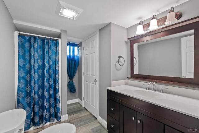 337 Virginia Ave, Appomattox, VA 24522 - bathroom featuring wood finished floors, toilet, baseboards, vanity, and curtained shower