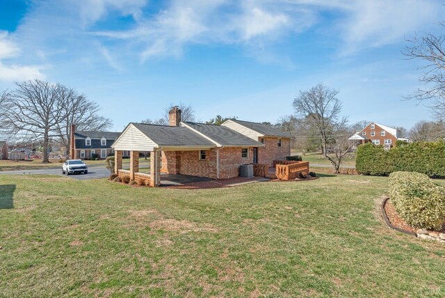 337 Virginia Ave, Appomattox, VA 24522 - back of house with brick siding, a lawn, a chimney, and central AC