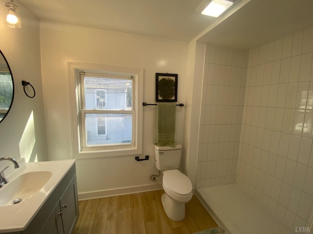 623 Monroe St, Lynchburg, VA 24504 - full bath featuring wood finished floors, toilet, vanity, baseboards, and tiled shower