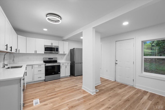 623 Monroe St, Lynchburg, VA 24504 - kitchen featuring a sink, appliances with stainless steel finishes, backsplash, light countertops, and baseboards