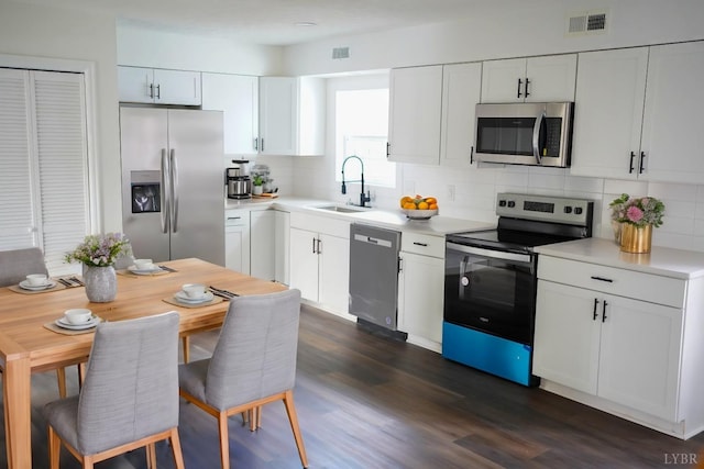 1417 Tunbridge Rd, Lynchburg, VA 24501 - kitchen featuring appliances with stainless steel finishes, tasteful backsplash, light countertops, white cabinets, and dark wood-type flooring