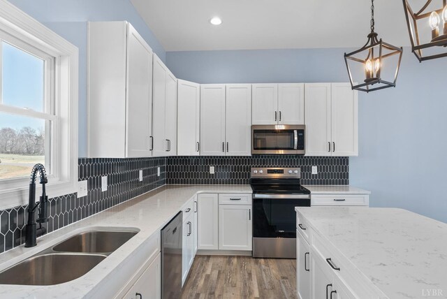 2135 Bellevue Rd, Forest, VA 24551 - kitchen featuring appliances with stainless steel finishes, light stone counters, decorative backsplash, white cabinetry, and light wood-style floors