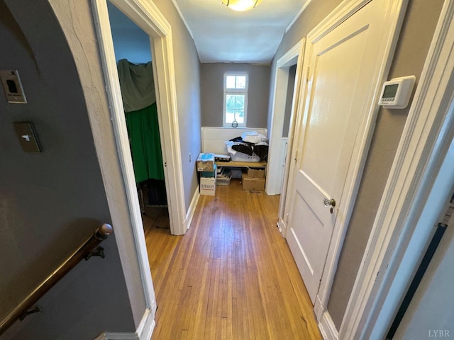 hallway with an upstairs landing, light wood-type flooring, and baseboards