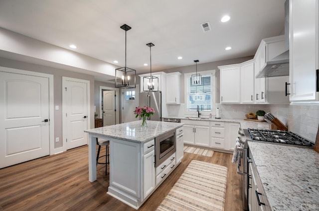 706 Elmwood Ave, Lynchburg, VA 24503 - kitchen with light wood-style flooring, a breakfast bar area, visible vents, a sink, and high end appliances