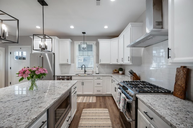 706 Elmwood Ave, Lynchburg, VA 24503 - kitchen with dark wood finished floors, a sink, wall chimney range hood, stainless steel appliances, and white cabinets