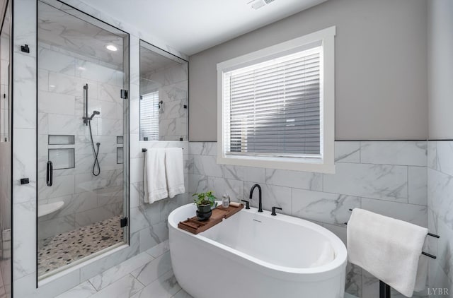 706 Elmwood Ave, Lynchburg, VA 24503 - full bathroom with tile walls, visible vents, a shower stall, a freestanding tub, and marble finish floor