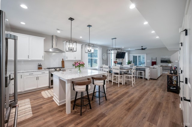 706 Elmwood Ave, Lynchburg, VA 24503 - kitchen featuring wall chimney range hood, range with two ovens, white cabinets, light stone countertops, and a kitchen island