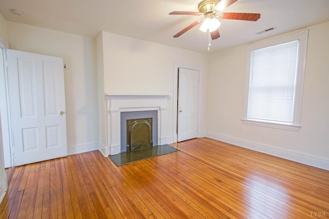 226 Denver Ave, Lynchburg, VA 24503 - unfurnished living room featuring a fireplace with raised hearth, visible vents, wood-type flooring, a ceiling fan, and baseboards
