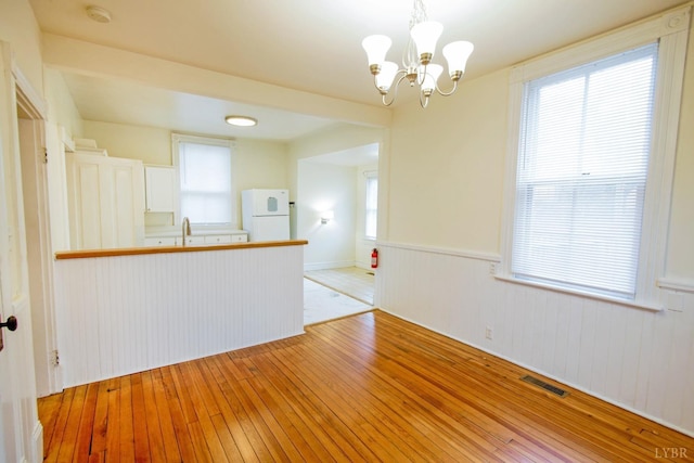 226 Denver Ave, Lynchburg, VA 24503 - unfurnished room with wainscoting, light wood finished floors, visible vents, and a chandelier