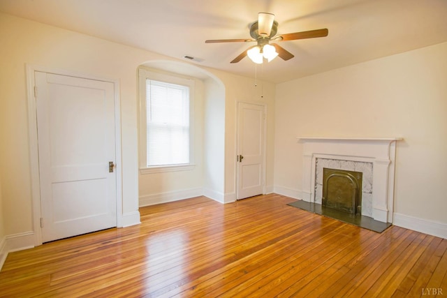 226 Denver Ave, Lynchburg, VA 24503 - unfurnished living room with visible vents, a fireplace, ceiling fan, arched walkways, and light wood-style floors