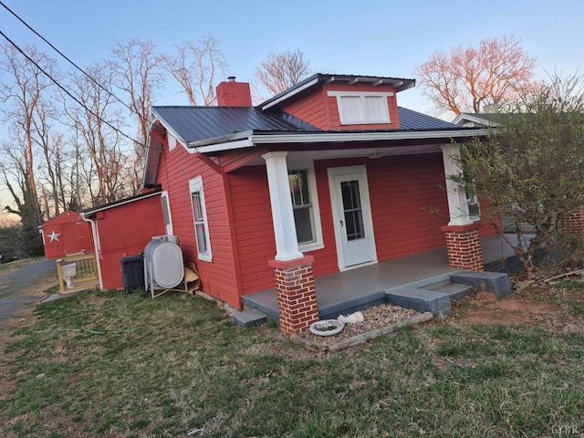 2608 Old Forest Rd, Lynchburg, VA 24501 - rear view of property featuring a porch, a lawn, a chimney, and metal roof