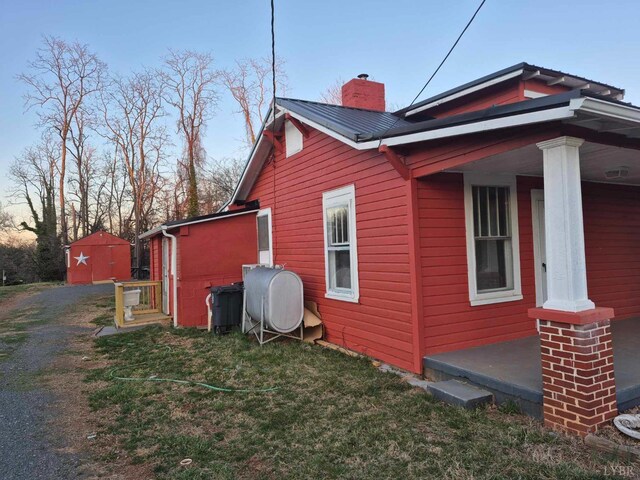 2608 Old Forest Rd, Lynchburg, VA 24501 - view of home's exterior with dirt driveway, a chimney, a yard, and metal roof