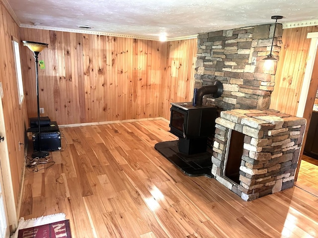 506 Peters Hollow Rd, Monroe, VA 24574 - unfurnished living room with crown molding, a wood stove, wood finished floors, and a textured ceiling