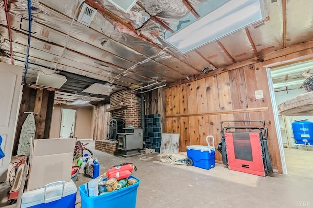 1553 Old Stage Rd, Amherst, VA 24521 - basement with a wood stove, a water pressure tank, and wood walls