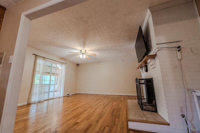 1553 Old Stage Rd, Amherst, VA 24521 - unfurnished living room featuring a textured ceiling, light wood-style floors, a ceiling fan, and a fireplace