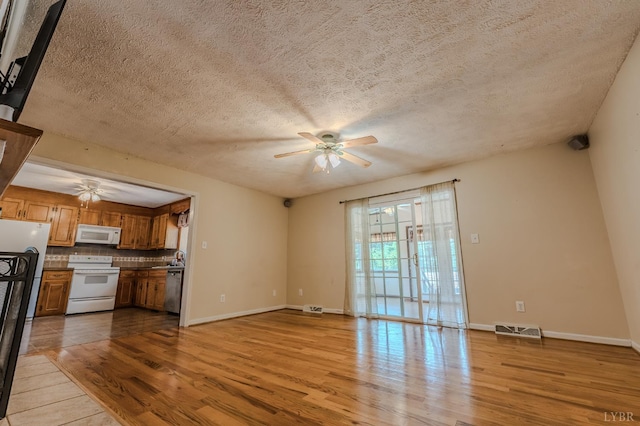 1553 Old Stage Rd, Amherst, VA 24521 - unfurnished living room featuring ceiling fan, light wood-style flooring, and a textured ceiling